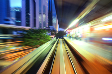Speedy trains passing train station. Focus on the rail road.