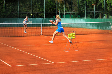 Two young women playing tennis outdoors on Two young womwn playi