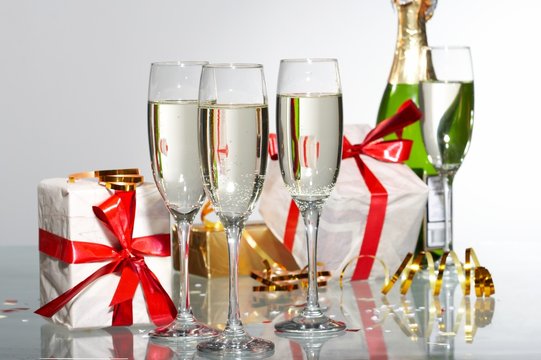 Glasses of champagne, gifts with red tapes and bows