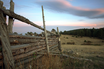 Atardeciendo en el prado con valla de madera