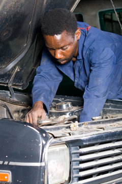 african machanic working on a broken down car