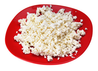 Big red plate with cottage cheese on the white background.