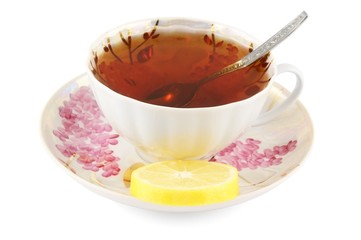 Cup of tea with lemon and teaspoon on white