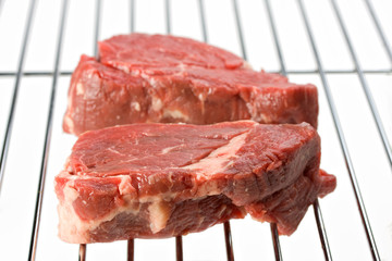 raw steak on a grill isolated on white