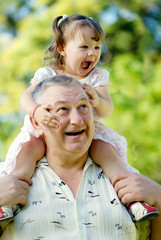 The grandfather with grand daughter in park