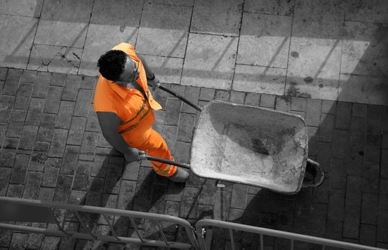Spanish contruction worker, hand truck, orange security clothes