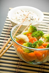 Closeup of bowls with vegetarian salad, rice and chopstic