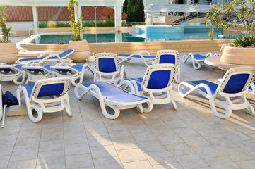 Empty chairs by the pool of  hotel