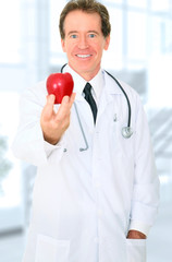 Senior Doctor Offering Red Apple To Patient