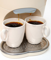 Coffee maker and two cups of black coffee