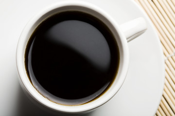 white cup of coffee over bamboo background