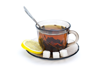 Teacup with black tea lemon slice and some sugar pieces