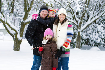 Fototapeta na wymiar Happy family during winter in the snow