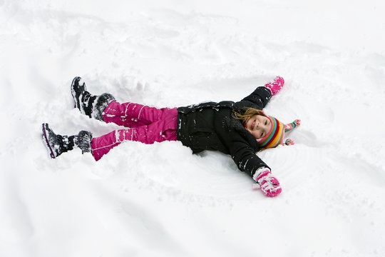 Young Girl Making A Snow Angel