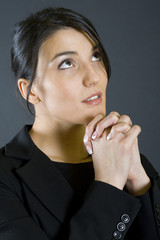 attractive young businesswoman praying