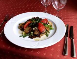 Dish of Italian cuisine - white mushroom salad on red tablecloth