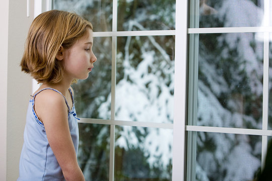 Girl Looking Out Window At Snow