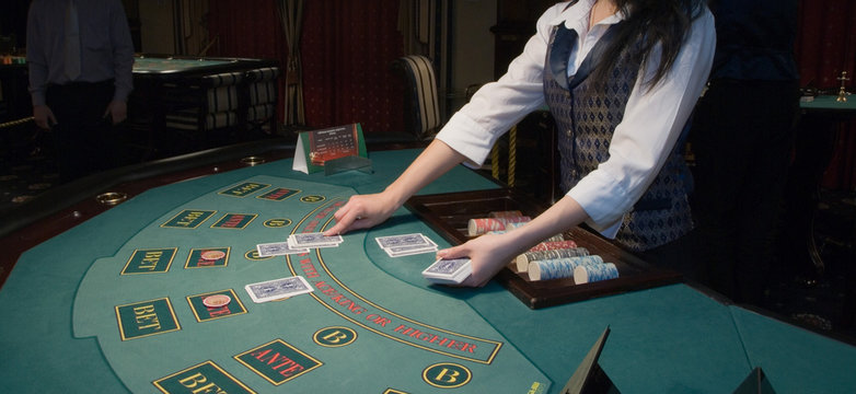 croupier handling cards at poker table