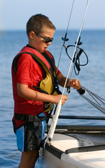 enfant gréant son catamaran