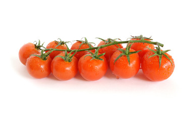 Bunch of cherry tomatoes with water drops isolated on white