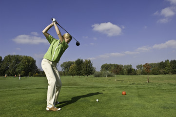 junge Golferin beim Abschlag