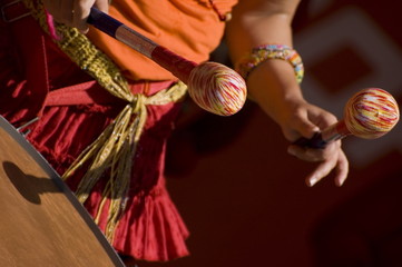 Women playing the orange drum.