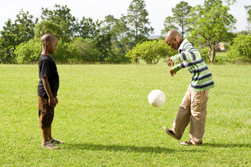 two african boys playing soccer