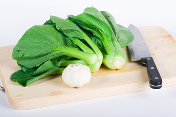 bok-choy with garlic and knife on cutting board