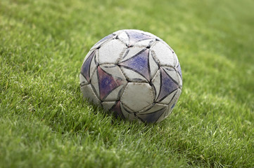 Fototapeta na wymiar old soccer ball on the grass