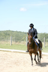 black teenage girl riding her horse in the show ring