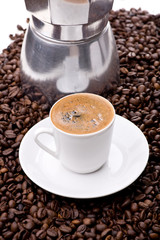 Espresso auf Untertasse vor Espressomaschine aus Metall