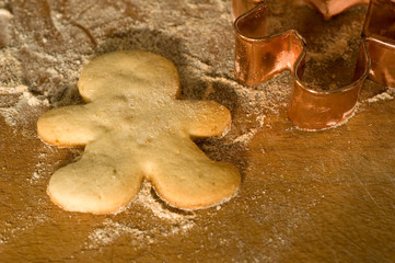 Gingerbreadman and a cookie cutter on a wooden board