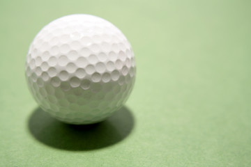 Golf ball on green background