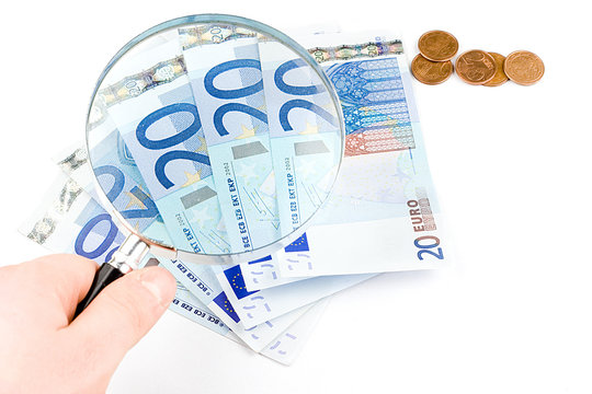 Isolated euro money under the reading glass kept in hand
