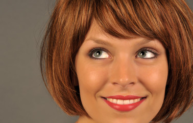 Naklejka premium Beautiful woman with red hair smiling and looking left.