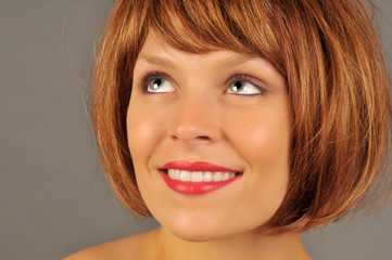 Naklejka premium Beautiful woman with red hair smiling and looking upward.