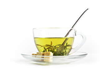 a glass cup of herbal tea with three pieces of brown sugar