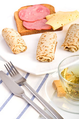 three pancake rolls, herbal tea and a sandwich