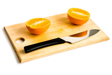 still life with orange knife and wood plate