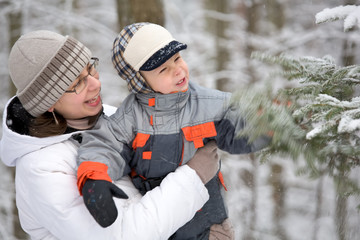 Boy with mom in winter forest