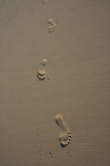 Trois empreintes de pied dans le sable