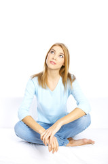 Young woman sitting on couch with crossed legs