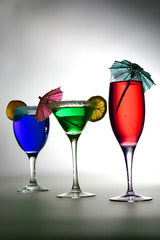 three coctails lighted background