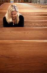 Woman praying in church pew
