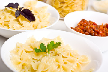 two bowls of butterflies pasta and bolognese sauce in a bowl