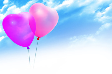 Fototapeta na wymiar Colored balloons in a heart shape on blue sky