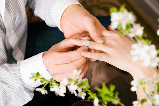 Verlobung – Mann steckt Frau den Ring an