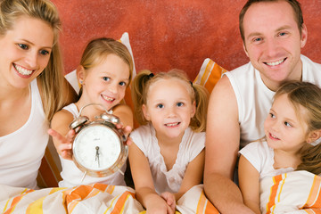 Familie morgens im Bett – Zeit aufzustehen