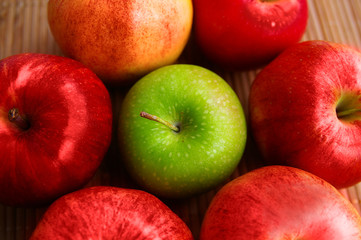 Fototapeta na wymiar one green apple among red ones