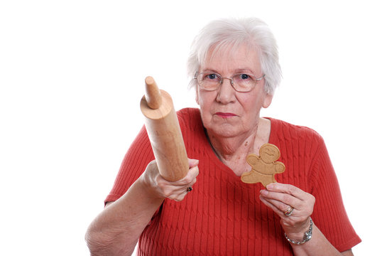 senior woman protecting gingerbread men cookies